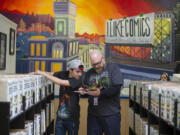 Gateway to Adult Transition Education program member Brayden Oh, left, works with special education teacher Mark Shellenberger as they organize comics at I Like Comics on Thursday morning. The program helps students with developmental disabilities gain job skills and connect with social services.