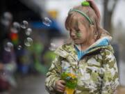 Six-year-old Abbygale Harris of Vancouver gets into the spirit of the holiday with festive green face painting and bubbles while waiting in Uptown Village for the annual Paddy Hough Parade to start Friday afternoon, March 17, 2017.