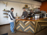 Customer Fred Lee, from left, chats with owner Mitch Montgomery as he works with barista Sam Morse at Relevant Coffee. The cafe opened in Uptown Village last week.