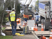 NW Natural foreman Mike Morgan, on ground, talks to pipeline inspector Derek Norwood while moving a gas line from under Southwest 18th Street in Battle Ground.