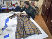 Eileen Trestain, who manages the costume department at Fort Vancouver, examines a silk dress that was made around 1850. It had belonged to Maria Barclay, whose husband, Dr. Forbes Barclay, was the physician at Fort Vancouver during the 1840s.