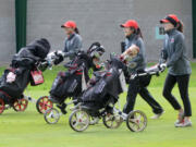 Camas golfers Lauryn Tsukimura, left, Abby Jiang, and Emma Cox walk down the first fairway at Club Green Meadows on Thursday, March 30, 2017.