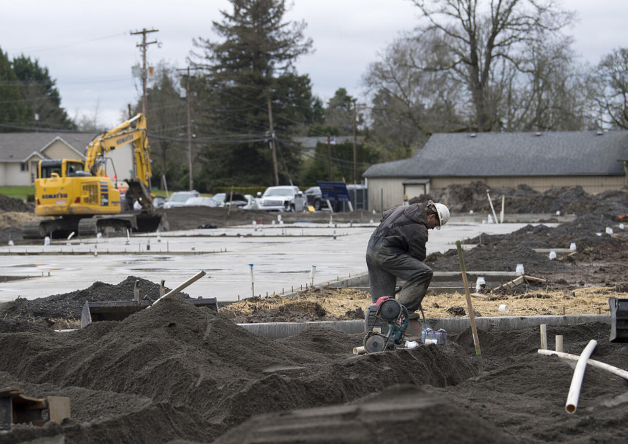 Clint Brade of RSP Plumbing prepares the interior plumbing for Arcadia Crossing along Northeast 68th Street on Wednesday afternoon. Apartment construction in the suburbs of the Portland metro area is at its most active since 1996.