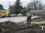 Clint Brade of RSP Plumbing prepares the interior plumbing for Arcadia Crossing along Northeast 68th Street on Wednesday afternoon. Apartment construction in the suburbs of the Portland metro area is at its most active since 1996.