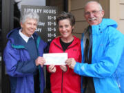 Ridgefield: Rhonda Pfeifer, Dick Hannah Dealerships vice president assistant, center, presents Kathy Winters, left, and Tevis Laspa with a $13,000 check for the Ridgefield Community Library building fund.