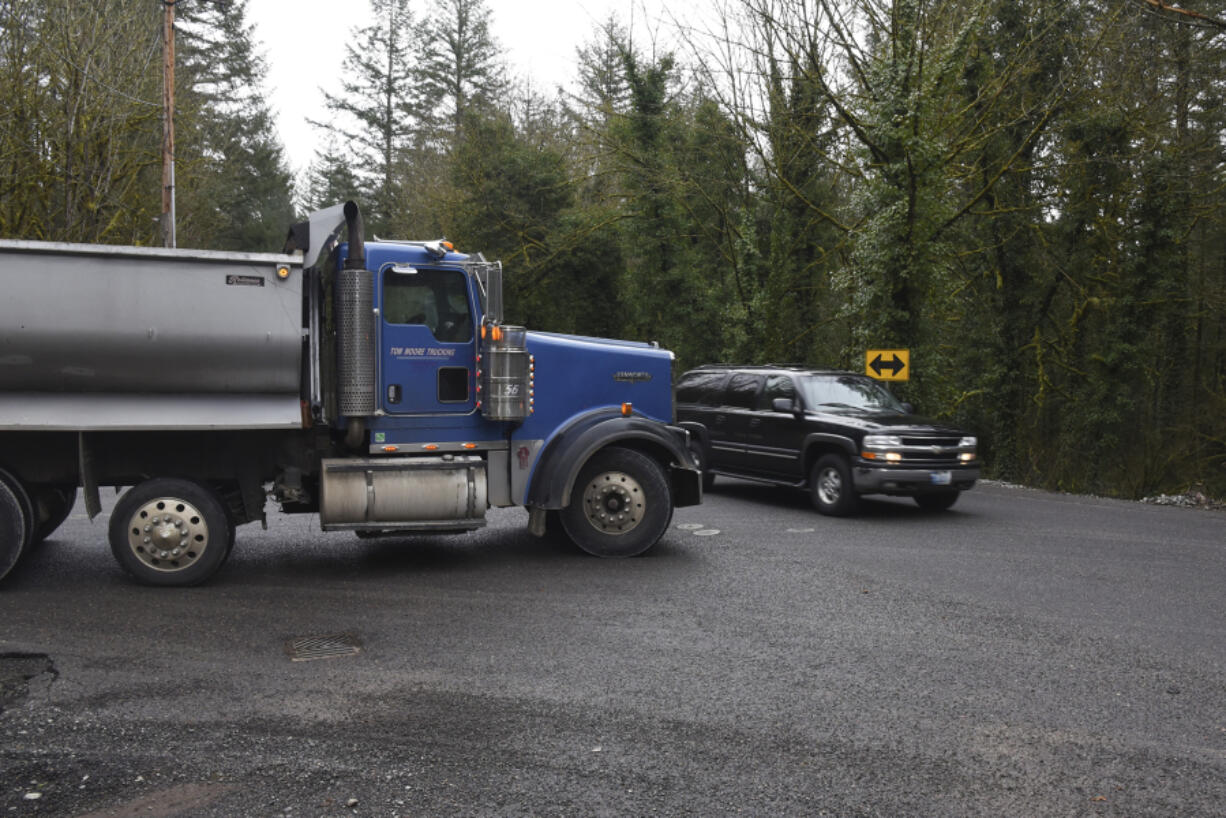 A truck from Yacolt Mountain Rock Quarry on Northeast Kelly Road waits for a vehicle to pass on Northeast Lucia Falls Road west of Yacolt.