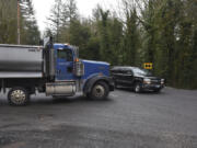 A truck from Yacolt Mountain Rock Quarry on Northeast Kelly Road waits for a vehicle to pass on Northeast Lucia Falls Road west of Yacolt.