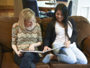 Heather Radu, founder of Dorie&#039;s Promise, an orphanage in Guatemala, left, looks at a photo album of the orphanage with Nallely Lux, 19, at Radu&#039;s home in Camas. Lux, the first orphan from Dorie&#039;s Promise to obtain a visa and move to the United States, currently lives in Vancouver and is enrolled at Clark College.