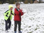 Kindergartener Evan Salmon, center, prepares a giant snowball while Daniel Blaser sneaks up behind him with a snowball during recess at Prune Hill Elementary School on Dec. 5. There was school that day, but the Camas School District canceled 10 days of school this school year due to snow and inclement weather. The district received a waiver for four of those days.