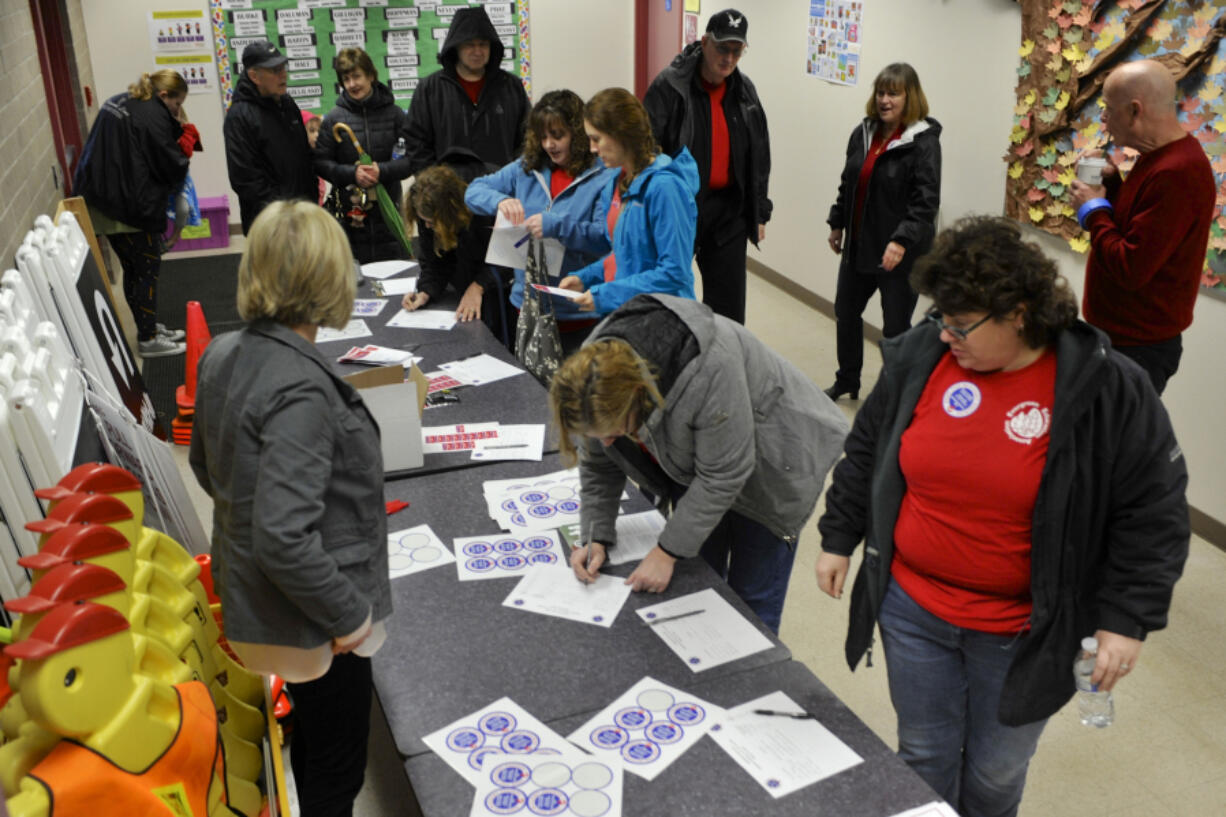 Participants sign in Saturday at a school funding rally with legislators at Roosevelt Elementary School in Vancouver.