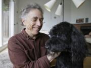 In this photo taken Wednesday, Feb. 15, 2017, Michael Fasman poses with his dog Hudson at his home in San Francisco. As more states legalize marijuana for humans, more pet owners are giving their furry companions cannabis-based extracts, ointments and edibles marketed to treat everything from arthritis and anxiety to seizures and cancer.