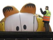 FILE - In this Nov. 27, 2008, file photo, the Garfield the Cat helium balloon appears to be peering at a Chicago Transit Authority worker on the elevated tracks inside Chicago's famed Loop during the Thanksgiving Day Parade in Chicago. Garfield creator Jim Davis sought to quell a controversy over the cat's gender by telling The Washington Post on Feb. 28, 2017, that the cat is male.