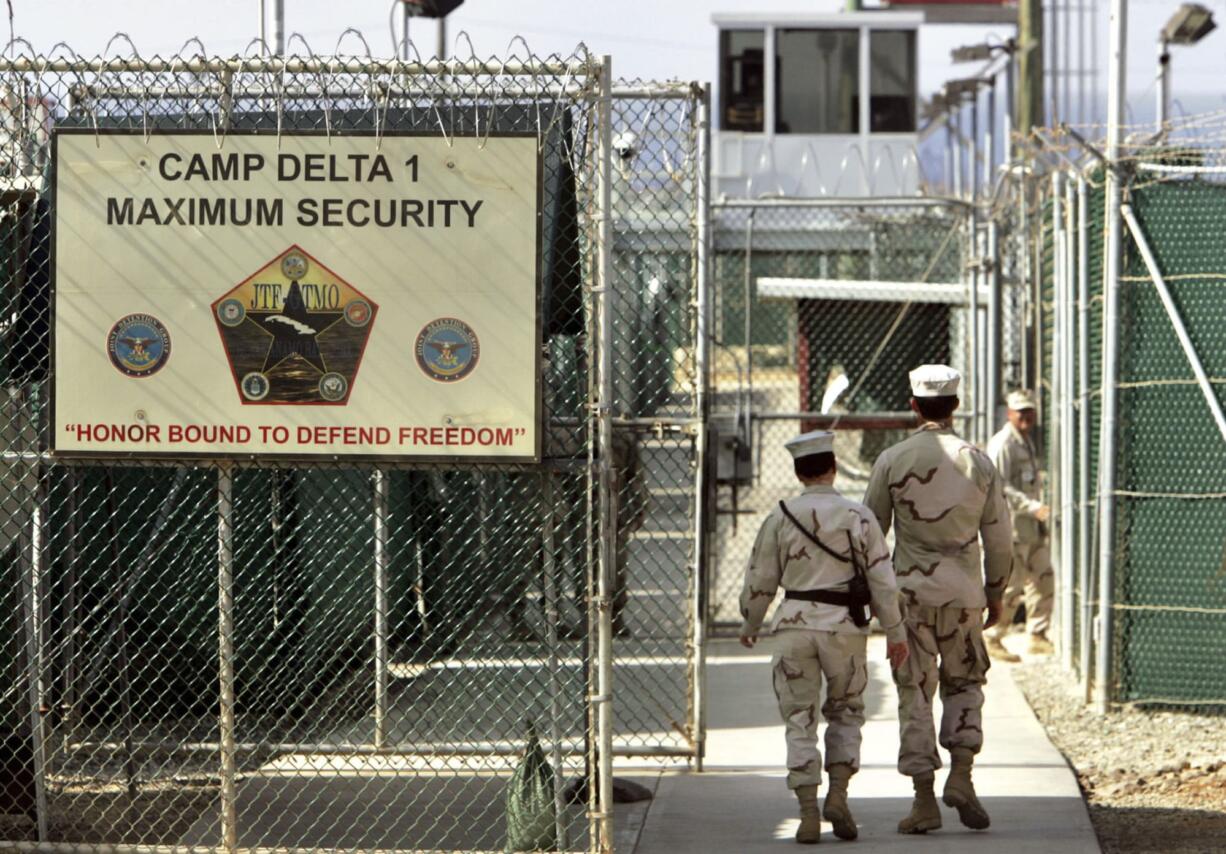 FILE - In this June 27, 2006 file photo, reviewed by a U.S. Department of Defense official, U.S. military guards walk within Camp Delta military-run prison, at the Guantanamo Bay U.S. Naval Base, Cuba.