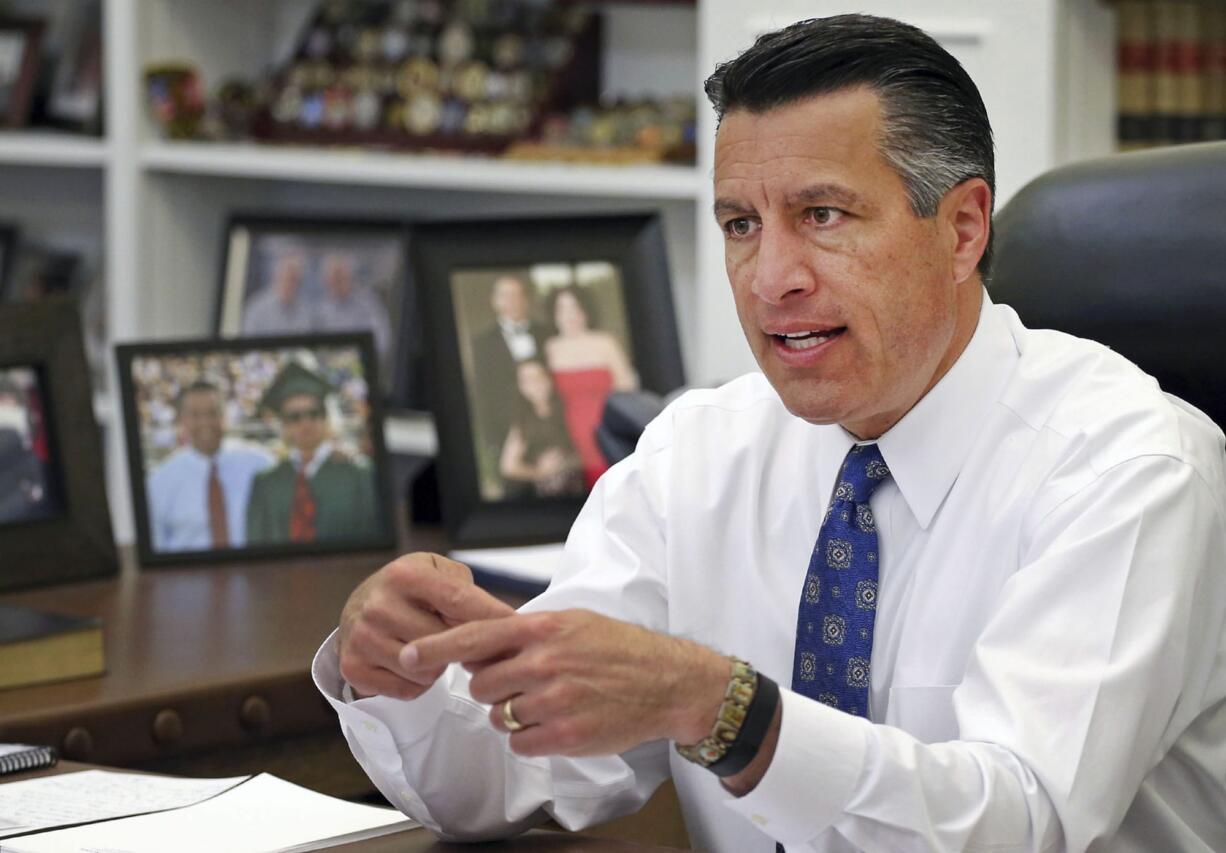 FILE - In this April 17, 2015, file photo, Nevada Gov. Brian Sandoval sits in his office at the Capitol in Carson City, Nev. Mirroring concerns raised by Democrats, Republican governors including Sandoval complain that the proposal from the GOP-controlled U.S. House to replace the existing health care law would force millions of lower-income earners from insurance rolls or stick states with the cost of keeping them covered.