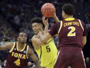 Oregon's Tyler Dorsey, center, drives between Iona's Schadrac Casimir, left, and E.J. Crawford, during the first half of a first-round game in the men's NCAA college basketball tournament Sacramento, Calif. Friday, March 17, 2017.