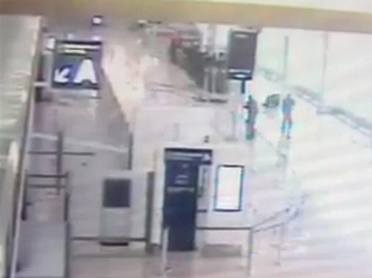 In this image taken from video of CCTV footage provided to AP on the condition that its source not be revealed, suspected Islamic extremist Ziyed Ben Belgacem remains on the ground, top left, after being shot by a soldier, as another soldier, who was previously held by him, second right, crawls away at Paris’ Orly airport, Saturday, March 18, 2017. The Associated Press has obtained security footage of the Saturday attack, which caused panic and shut down the French capital’s second-biggest airport.