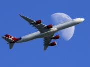 FILE - In this Sunday, Aug. 23, 2015, file photo, a Virgin Atlantic passenger plane crosses a waxing gibbous moon on its way to the Los Angeles International Airport, in Whittier, Calif. Alaska said Wednesday, March 22, 2017, that it will retire the Virgin brand, probably in 2019. Alaska announced in 2016, that it was buying Virgin, but CEO Brad Tilden held out hope to Virgin fans that he might keep the Virgin America brand, and run it and Alaska as separate airlines under the same corporate umbrella.