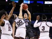 Washington guard Kelsey Plum (10) shoots over Mississippi State's Teaira McCowan (15), Dominique Dillingham (00) and Breanna Richardson (3) during the second half of a regional semifinal of the NCAA women's college basketball tournament, Friday, March 24, 2017, in Oklahoma City.