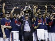 Gonzaga head coach Mark Few, center, holds a trophy as his players surround him after a win over Xavier in an NCAA Tournament college basketball regional final game Saturday, March 25, 2017, in San Jose, Calif.