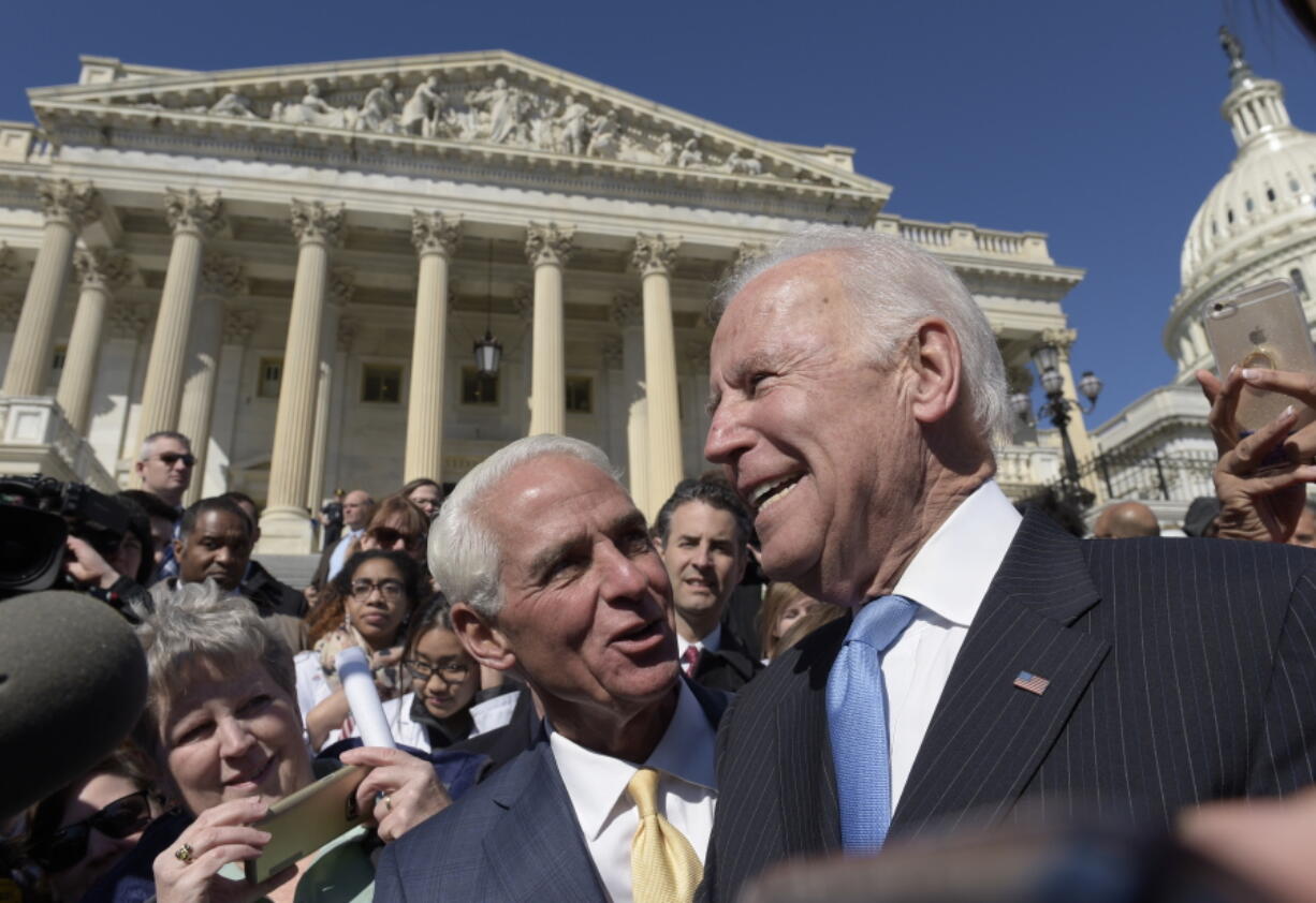 Former Vice President Joe Biden, right, and Rep. Charlie Crist, D-Fla., second from right, greet the people in the crowd on Capitol Hill in Washington on Wednesday following an event marking seven years since former President Barack Obama signed the Affordable Care Act into law.