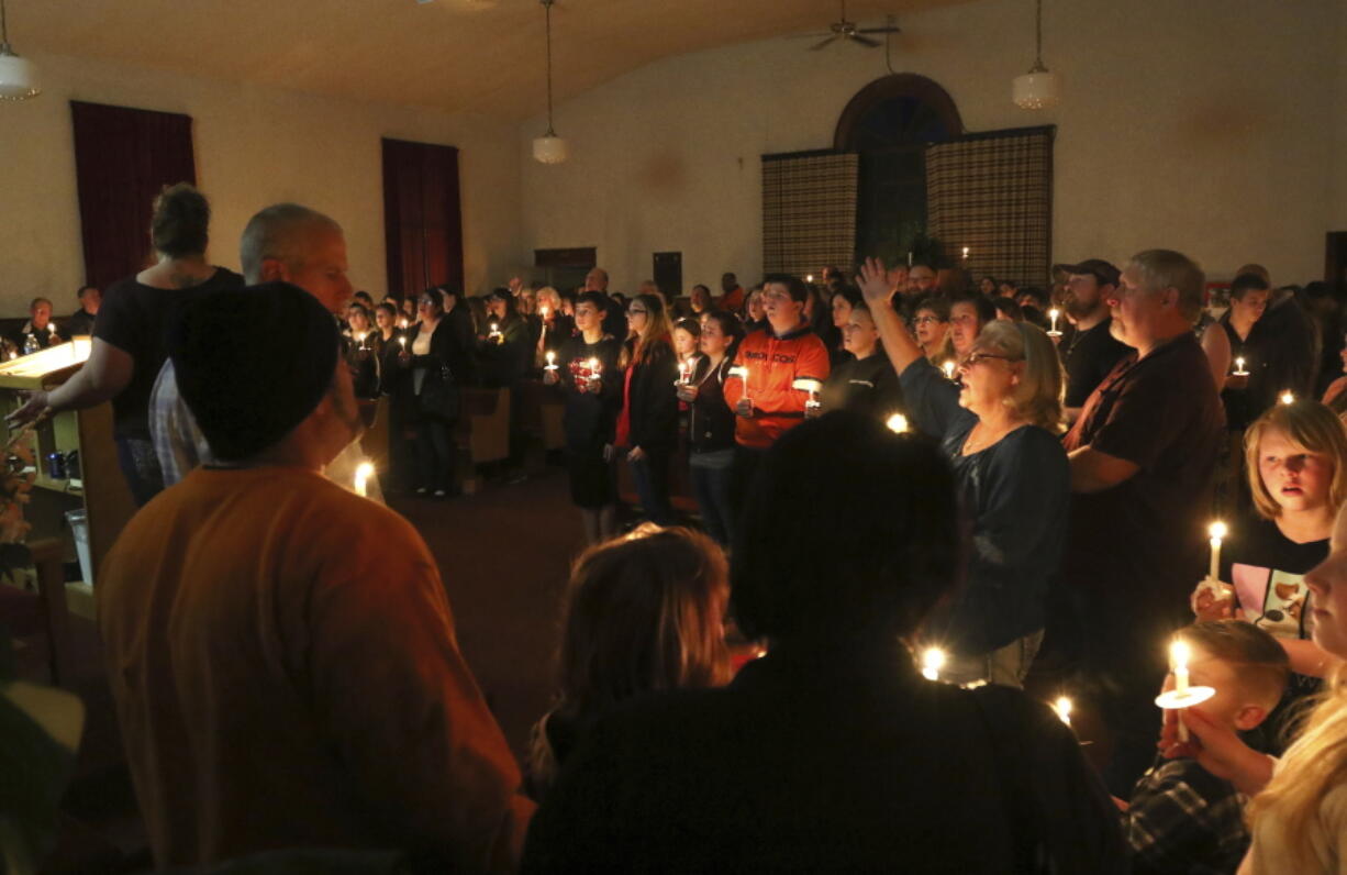 Community members participate in a candlelight vigil for the victims of a house fire at a Riddle home earlier in the day Wednesday night in Riddle, Ore. Several children died in a house fire Wednesday in an Oregon timber town and their mother, her husband and a 13-year-old sibling were critically injured, a sheriff&#039;s official said. The cause of the blaze did not appear suspicious, but an investigation was continuing, authorities said.