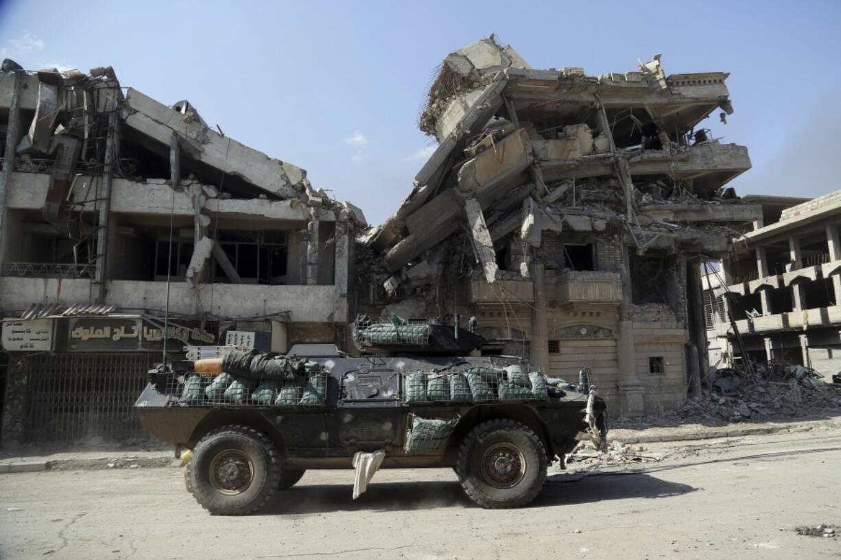 Iraqi security forces advance during fighting against Islamic State militants in Dawasa neighborhood in western Mosul, Iraq, Tuesday, March 7, 2017. U.S.-backed Iraqi forces were fighting their way through a government complex in the heart of western Mosul after storming the buildings in an overnight raid, and were facing fierce counterattacks Tuesday from the Islamic State group.