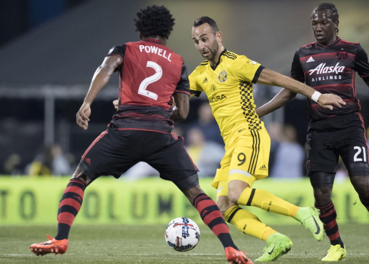 Columbus Crew forward Justin Meram advances the ball past Portland Timbers defender Alvas Powell during the first half of an MLS soccer match, Saturday, March 25, 2017, in Columbus, Ohio.