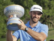 Dustin Johnson holds his trophy after defeating Jon Rahm of Spain at the Dell Technologies Match Play golf tournament at Austin County Club, Sunday, March 26, 2017, in Austin, Texas.