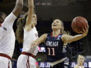 Gonzaga&#039;s Laura Stockton (11) drives the lane as Oklahoma&#039;s Vionise Pierre-Louis, left, and Maddie Manning defend during the first half of a first-round game in the NCAA women&#039;s college basketball tournament Saturday, March 18, 2017, in Seattle.