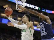 Oregon Ducks, Dillon Brooks, left, goes to the basket against Rhode Island forward Kuran Iverson during the first half of a second-round game of the NCAA men's college basketball tournament in Sacramento, Calif., Sunday, March 19, 2017.