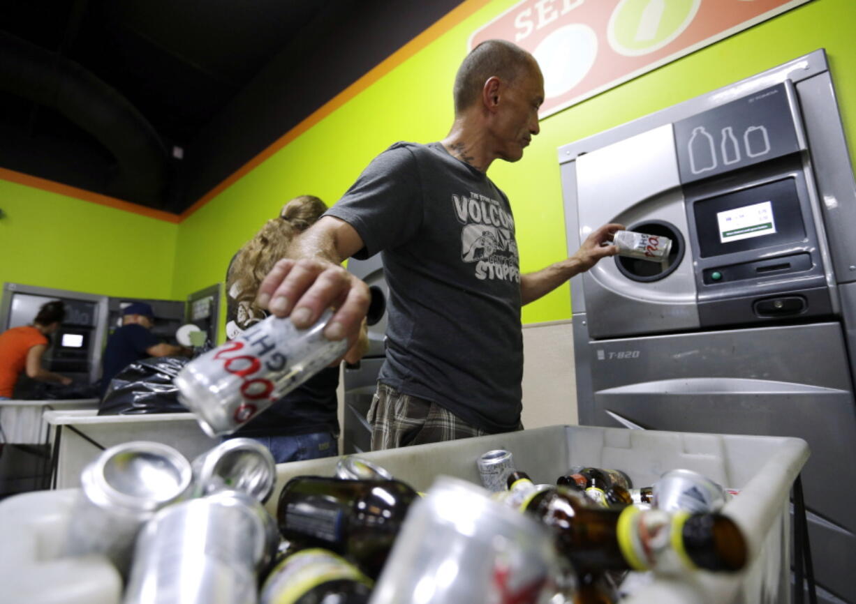 Michael Swadberg turns in bottles at a Bottledrop Oregon Redemption Center in Gresham, Ore., July 31, 2015. Oregon was the first state in the nation to give 5-cent refunds for recycling used water bottles and soda cans more than 45 years ago. Now, in an effort to boost recycling, the state is doubling that refund.