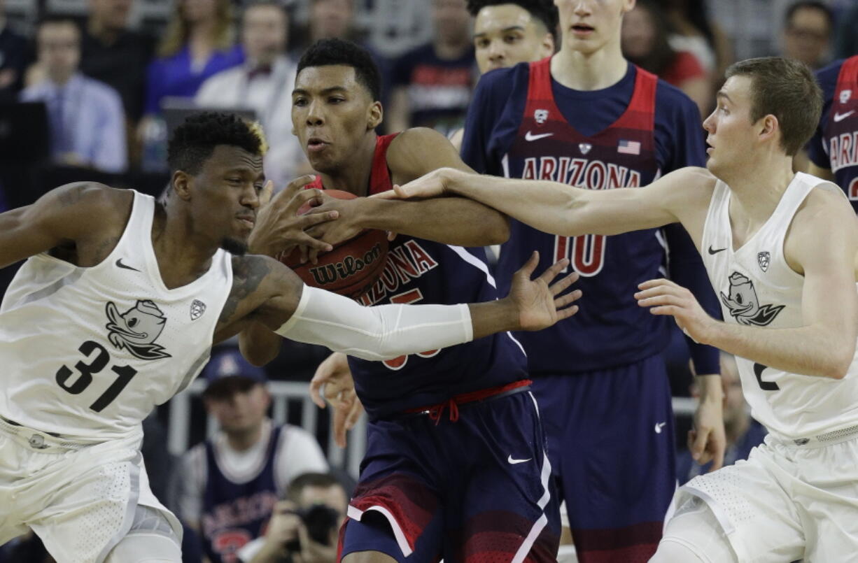 Arizona&#039;s Allonzo Trier, center, competes for the ball with Oregon&#039;s Dylan Ennis, left, and Casey Benson during the first half of an NCAA college basketball game for the championship of the Pac-12 men&#039;s tournament Saturday, March 11, 2017, in Las Vegas.