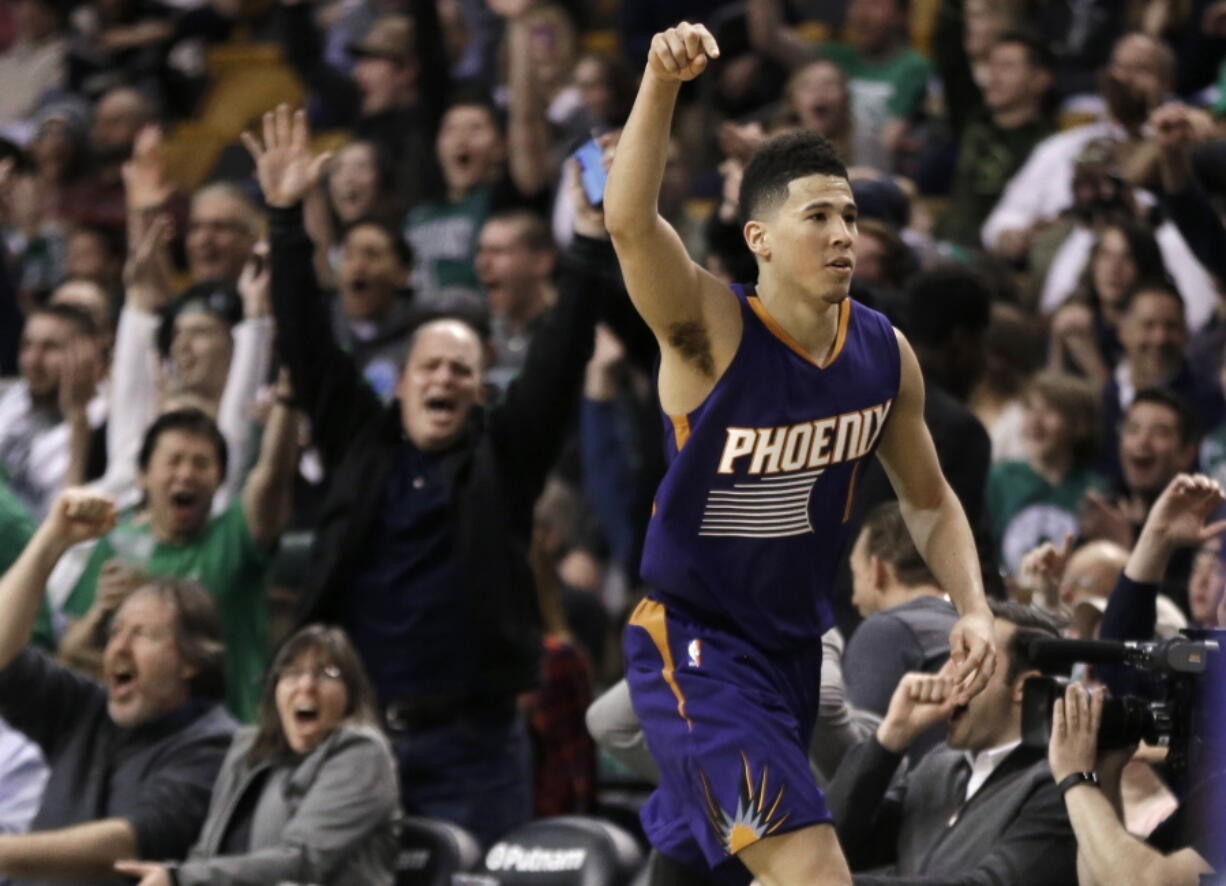 Phoenix Suns guard Devin Booker gestures after he scored a basket, as fans cheer him at TD Garden in the fourth quarter of the Suns&#039; 130-120 loss to Boston.