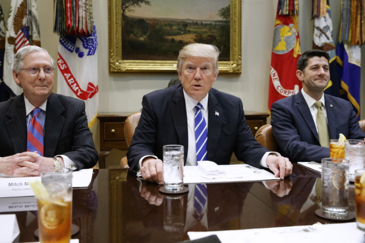 President Donald Trump, flanked by Senate Majority Leader Mitch McConnell of Ky. and House Speaker Paul Ryan of Wis., hosts a meeting with House and Senate leadership, Wednesday in the Roosevelt Room of the White House in Washington.