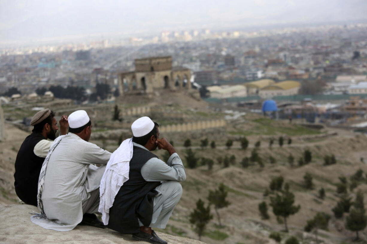 In this March 27, 2017, file photo, men sit on the Nadir Khan hilltop overlooking Kabul, Afghanistan. As AmericaC?Us 16-year war in Afghanistan drags on, Russia is resurrecting its own interest in the C?ugraveyard of empires.C?u The jockeying includes engaging the Taliban and leading a new diplomatic effort to tackle AfghanistanC?Us future, all while Washington leaves the world guessing on its strategy for ending the conflict.