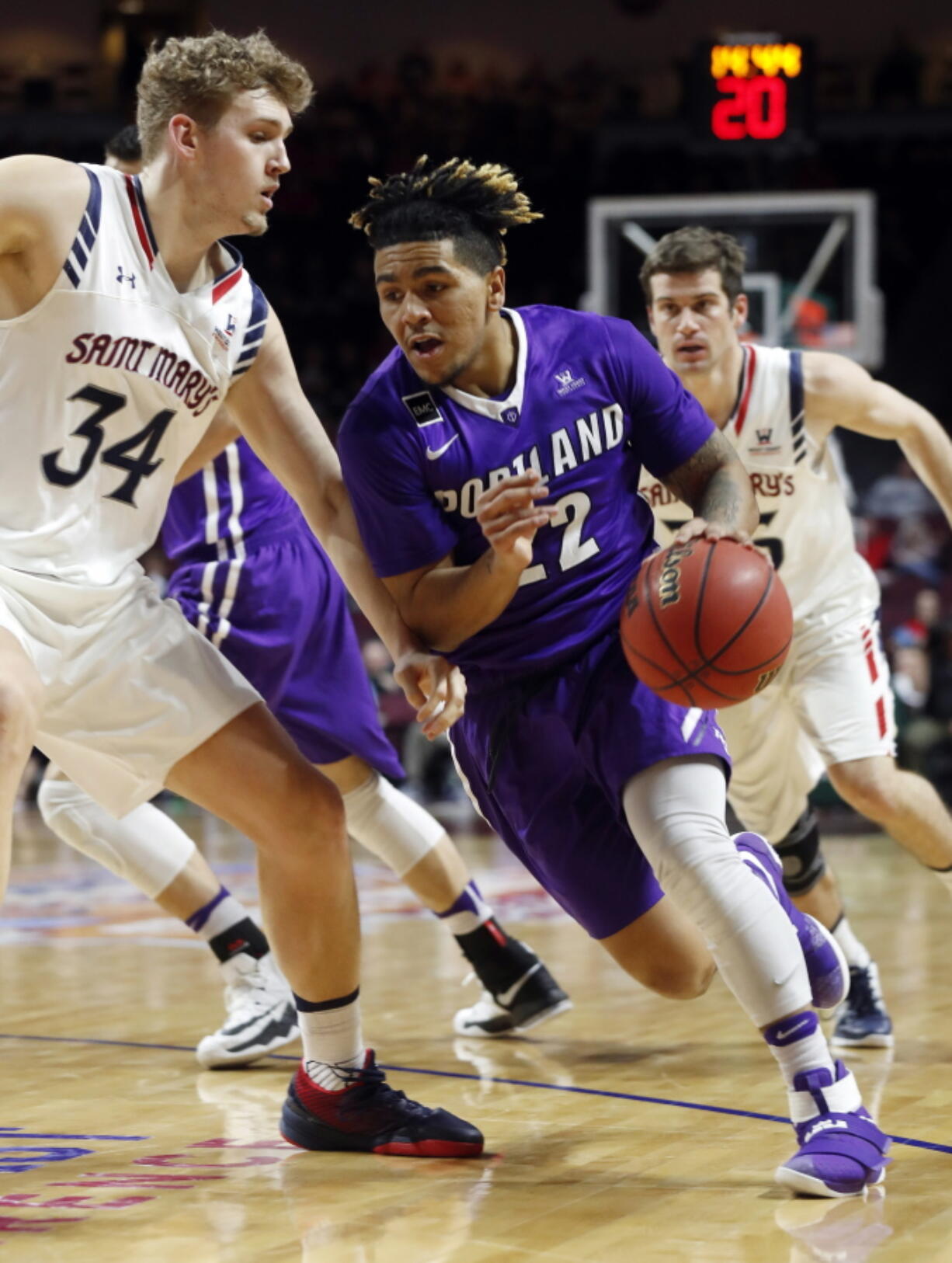 Portland&#039;s Jazz Johnson (22) drives to the basket as Saint Mary&#039;s Jock Landale defends during the first half of a West Coast Conference tournament NCAA college basketball game Saturday, March 4, 2017, in Las Vegas.