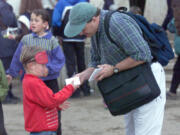 Brian Willoughby gives a Kosovar refugee boy a pen and paper at the Sports Palace in Korce, Albania, in 1999.