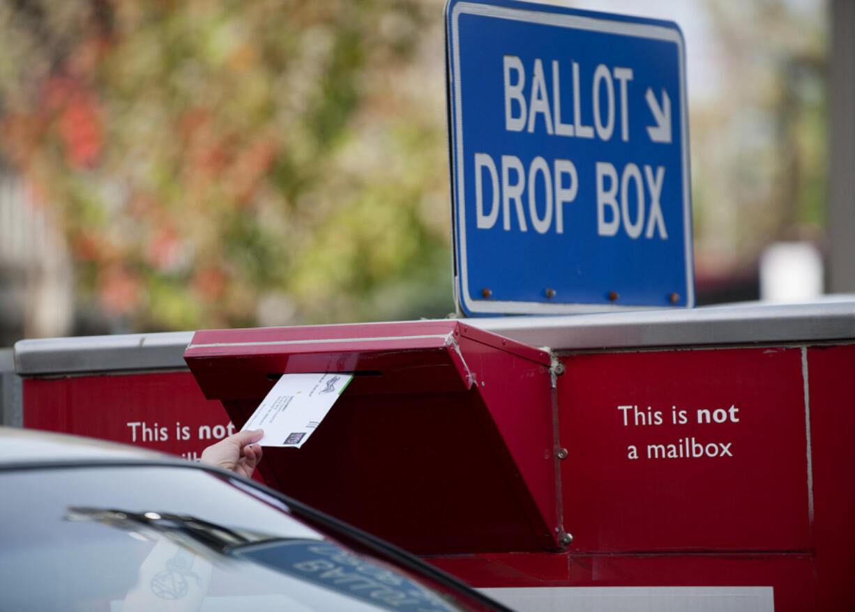 A voter drops off their ballot in the drop box on West 14th Street.