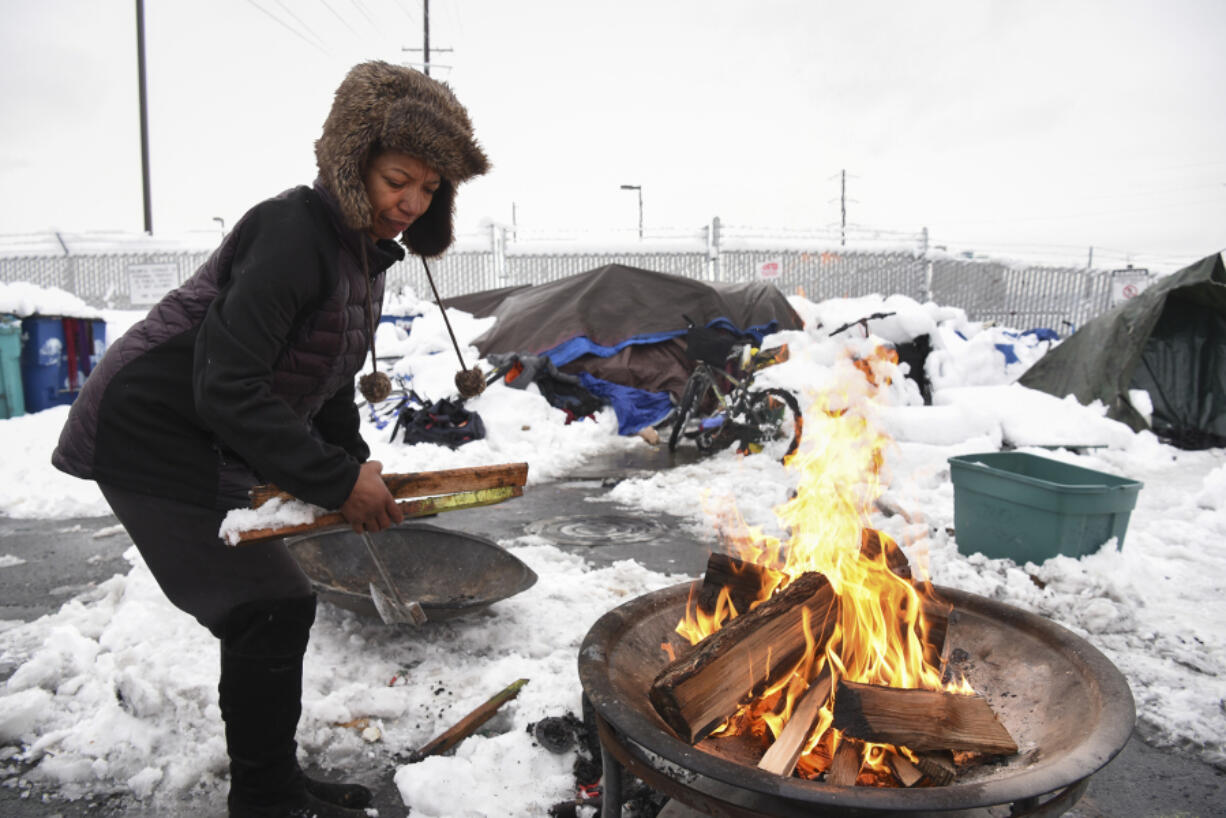 Tiffany Singleton builds a fire outside her tent on West 12th Street in Vancouver after a snowstorm in January. In a recent single-day census, The Council for the Homeless found 269 unsheltered people in Clark County this year, an 18 percent increase from last year.