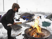 Tiffany Singleton builds a fire outside her tent on West 12th Street in Vancouver after a snowstorm in January. In a recent single-day census, The Council for the Homeless found 269 unsheltered people in Clark County this year, an 18 percent increase from last year.