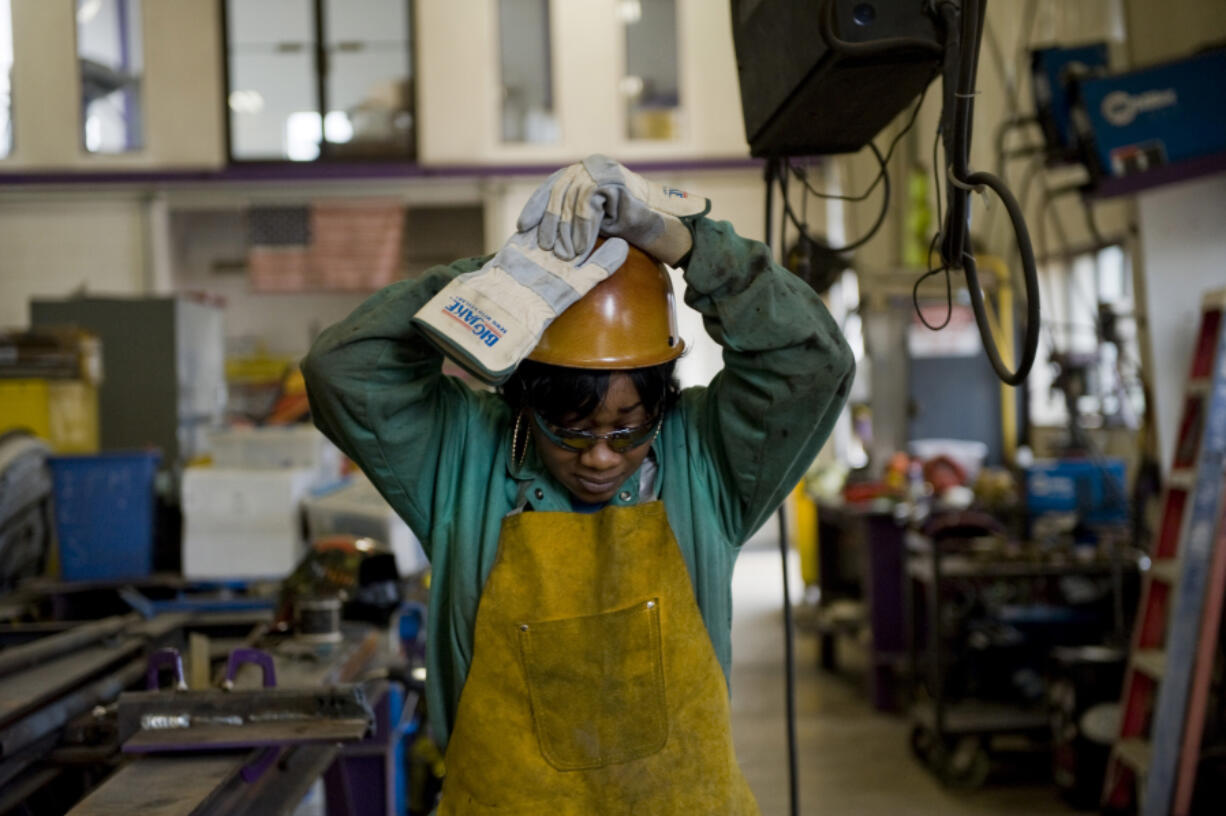 Journeywoman ironworker Bridget Booker dons her hard hat on a job site in East Peoria, Ill., on April 19.