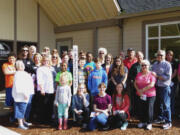 Clark County: Members of the Lewis River Rotary Club and kids from the Rocksolid Teen Community Center pose with a Peace Pole the Rotary planted, one of three they put up around Battle Ground recently.