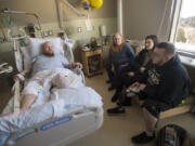 Paul Adams, clockwise from left, talks with his mom, Nancy Peterson, Jaden Carey and her brother, Justin Carey, during a hospital visit at PeaceHealth Southwest Medical Center on Monday. Adams and Carey both lost a leg after allegedly being struck by drivers from the same family.