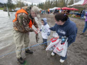 Volunteer Paul Pfeifer, from left, helps Alexander Nihipali, 5, and his mom, Leilani, catch a 23-inch, 6-pound rainbow trout during the annual Klineline Kids Fishing Derby. It was the biggest fish caught during the 9 a.m. hour on Friday.