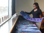 Alayah Willis, 13, holds a pair of jeans she decorated as part of the blue jean project at the Boys &amp; Girls Clubs O.K. Clubhouse. She said she painted triangles because they looked cool.