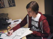 Ridgefield High School student Tatum Howlett works on a comic from her desk at her home in Battle Ground.