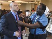 Nick Ak, a Career Clothing Closet volunteer, right, helps Clark College student George Esser with his necktie at the college’s Career Clothing Closet on Wednesday.