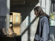 Local artist Jonathon David Turner looks over his wood-burning pictures on display at Vancouver Community Library as part of the Homeless not Hopeless art show.