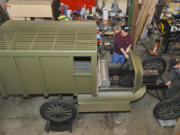 Lyle Wold, left, holds the gear shift lever as Tim Shotwell turns the engine crank of a 1917 Model T Ford they are transforming into a replica of a World War I Army ambulance.