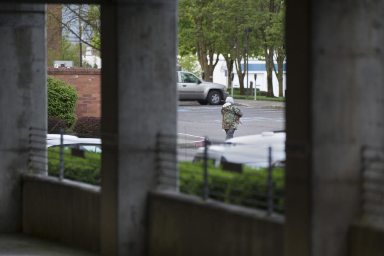 A man leaves the county&#039;s parking structure early in the morning before most employees arrive. Vancouver allows limited camping on public property, which includes the county building. The situation has created tension between county employees and homeless camped out in the structure. (Photos by Randy L.